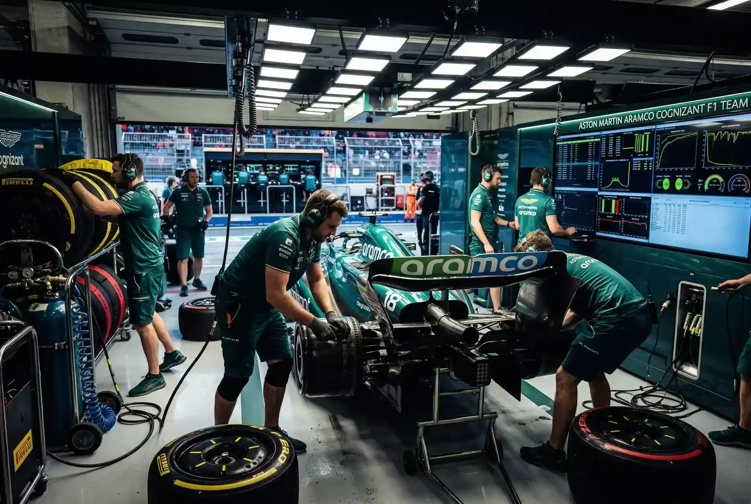 Box de escuderia F1 con mecanicos trabajando en monoplaza durante GP
