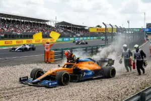 Monoplaza F1 detenido en la grava con humo saliendo del motor