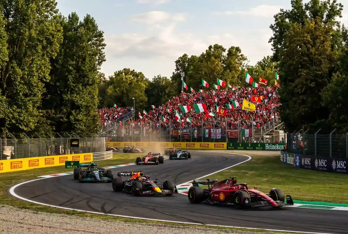 Monoplazas F1 a alta velocidad en la recta principal de Monza con los tifosi de fondo
