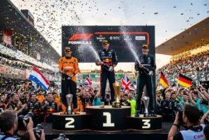 Tres pilotos de F1 celebrando en el podio con champan y trofeos